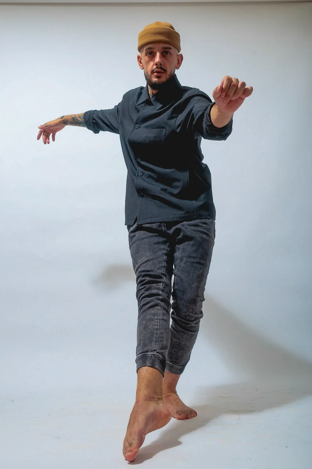 Gab balancing barefoot in a studio with arms extended