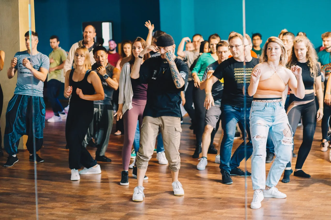 Gab exploring movement with a group of dancers during a workshop